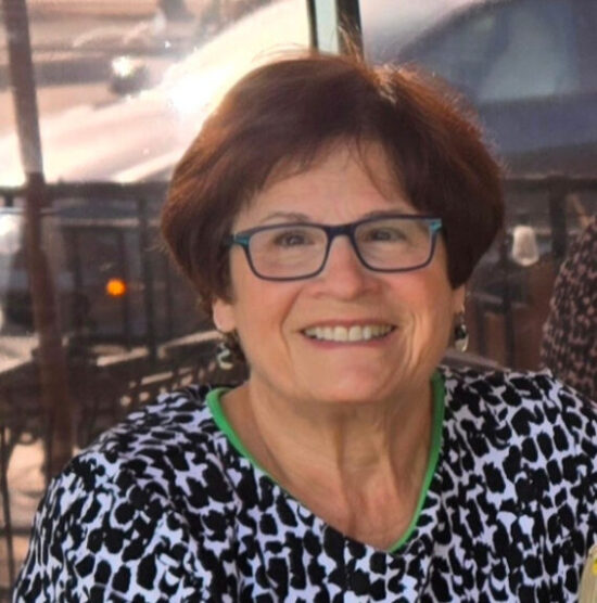 Ellen Merrill shares why she supports the arts in Johnson County. She has short brown hair and is wearing blue glasses.